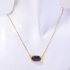 Gold necklace with a blue pendant on a white background