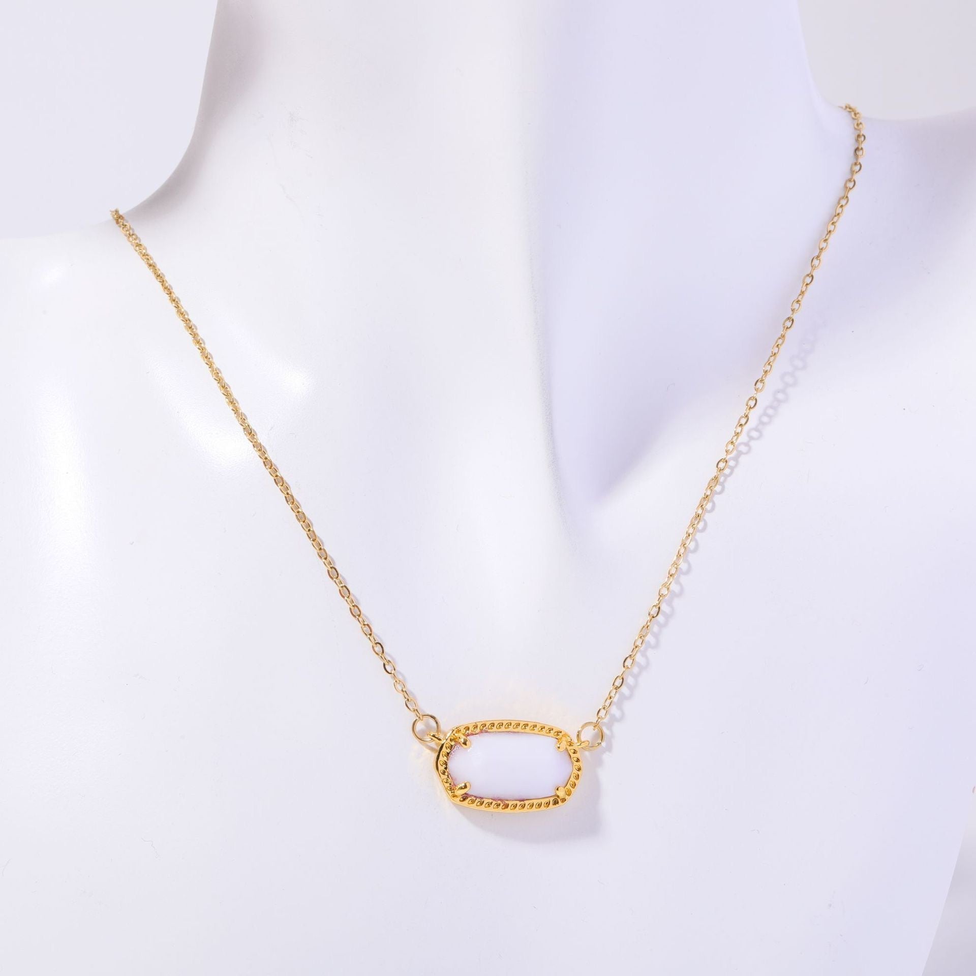 Gold necklace on a mannequin with a white background