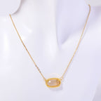 Gold necklace with a pendant on a mannequin against a white background