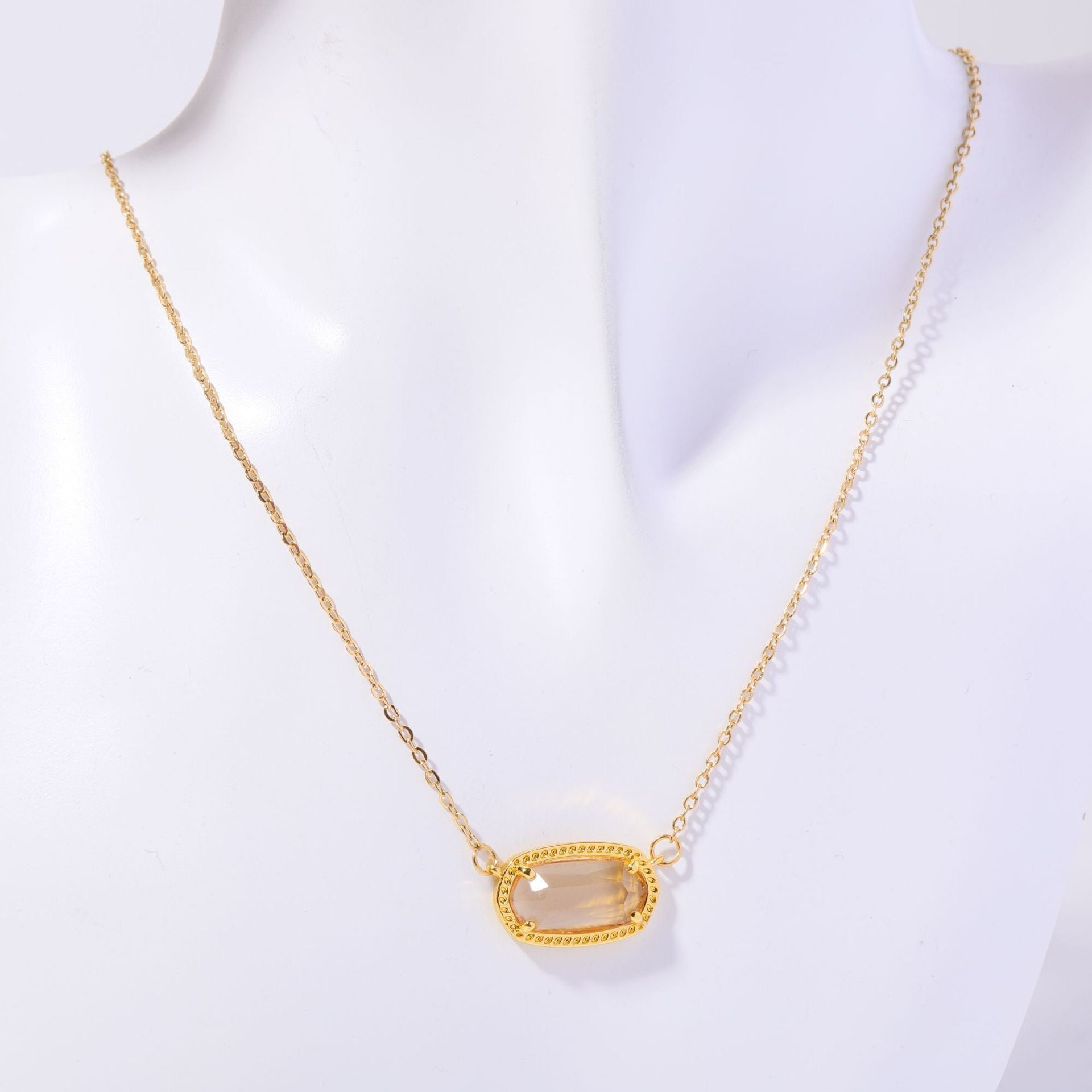 Gold necklace with a pendant on a mannequin against a white background