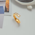 Gold ring with a clear gemstone on a light surface