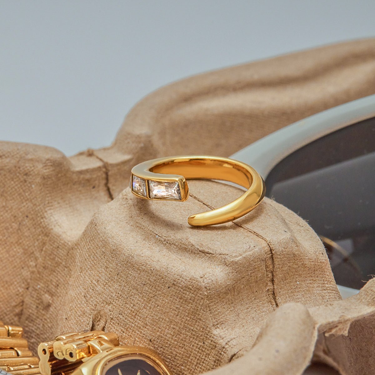 Gold ring with gemstones on a textured surface