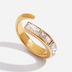 Gold ring with clear gemstones on a white background