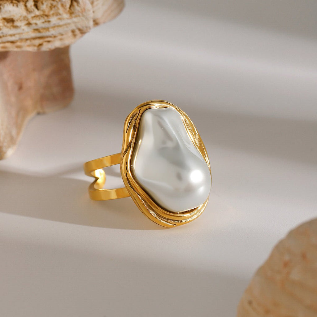 Gold ring with a large white pearl on a light background