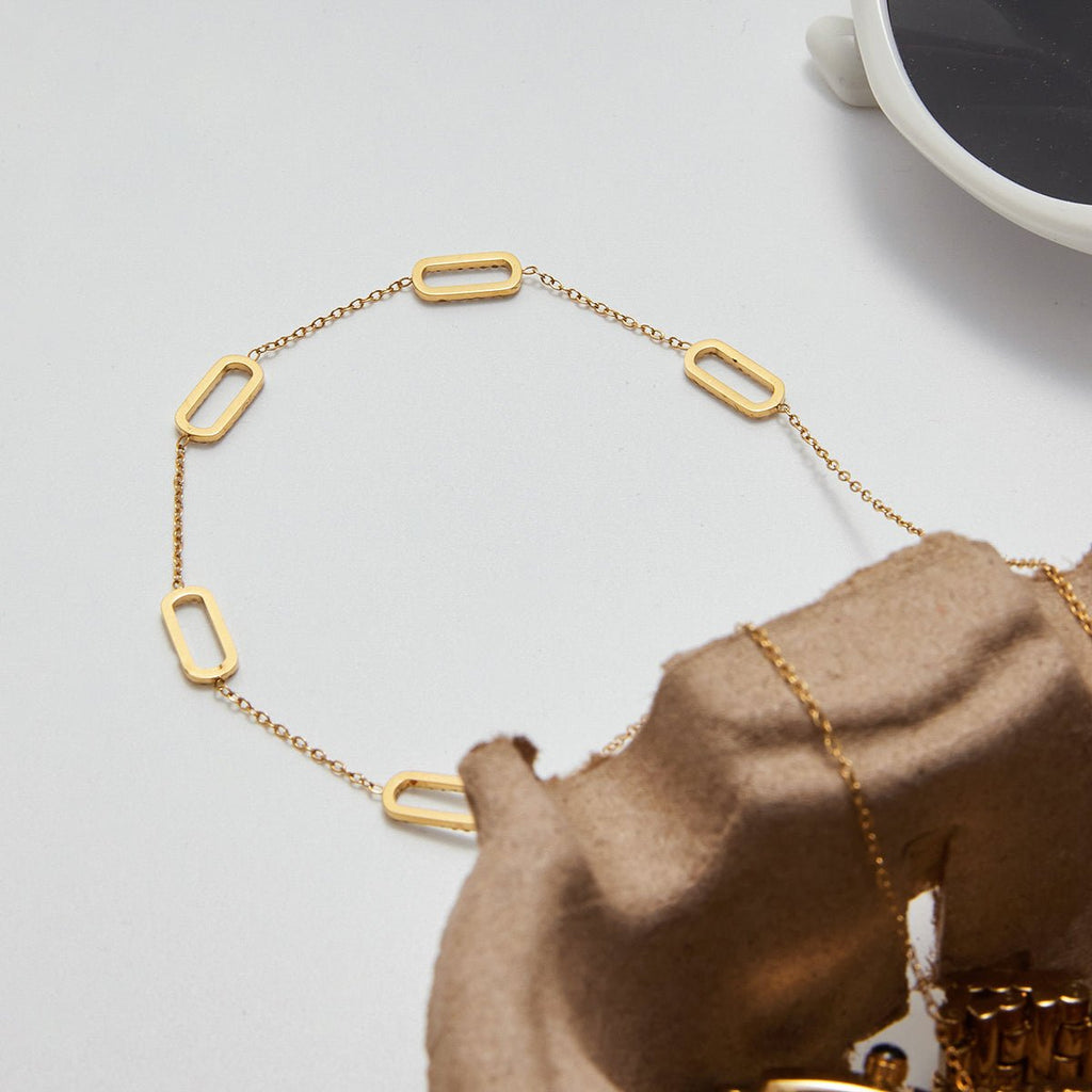Gold necklace on a textured surface with a blurred background