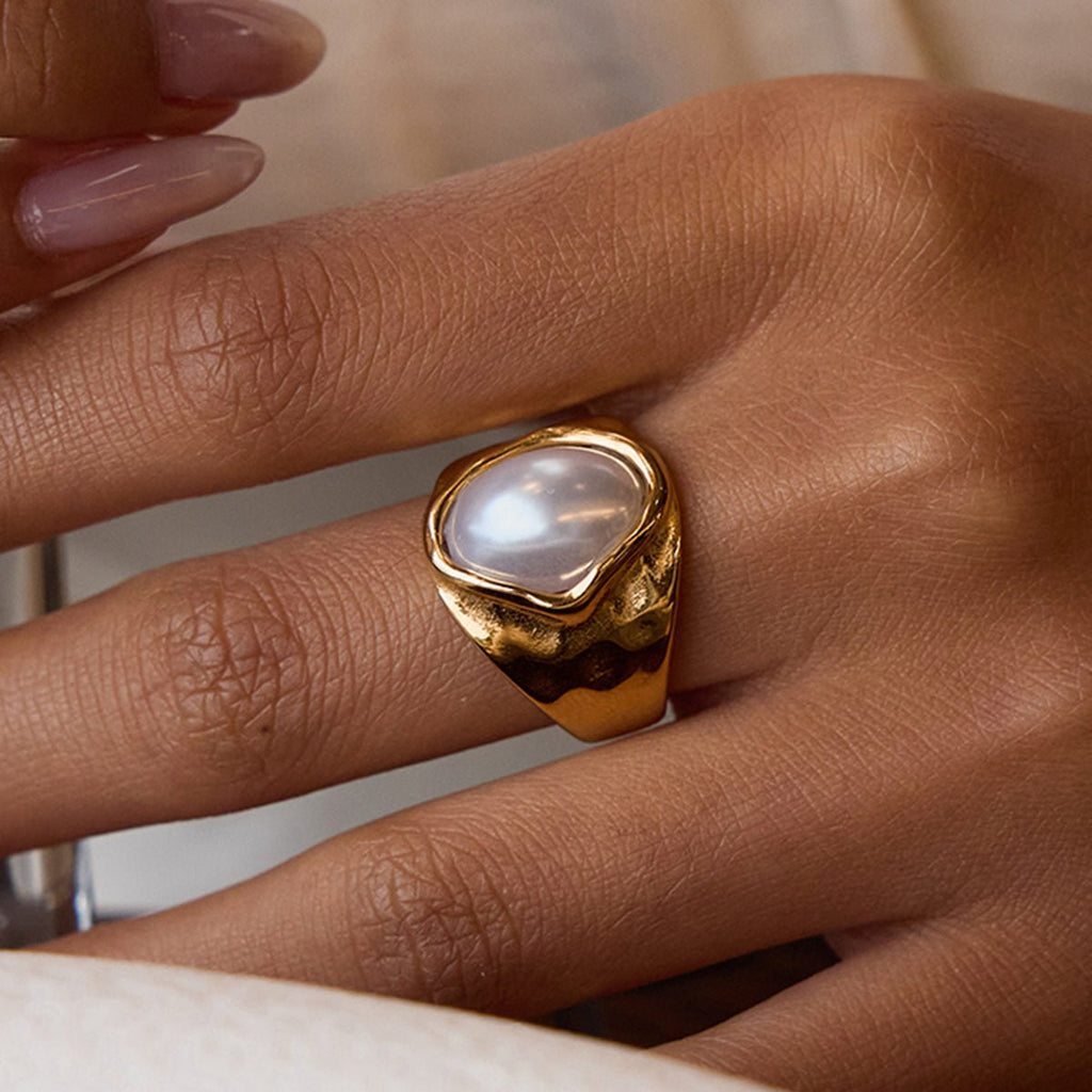 Gold and green gemstone jewelry set on a light background