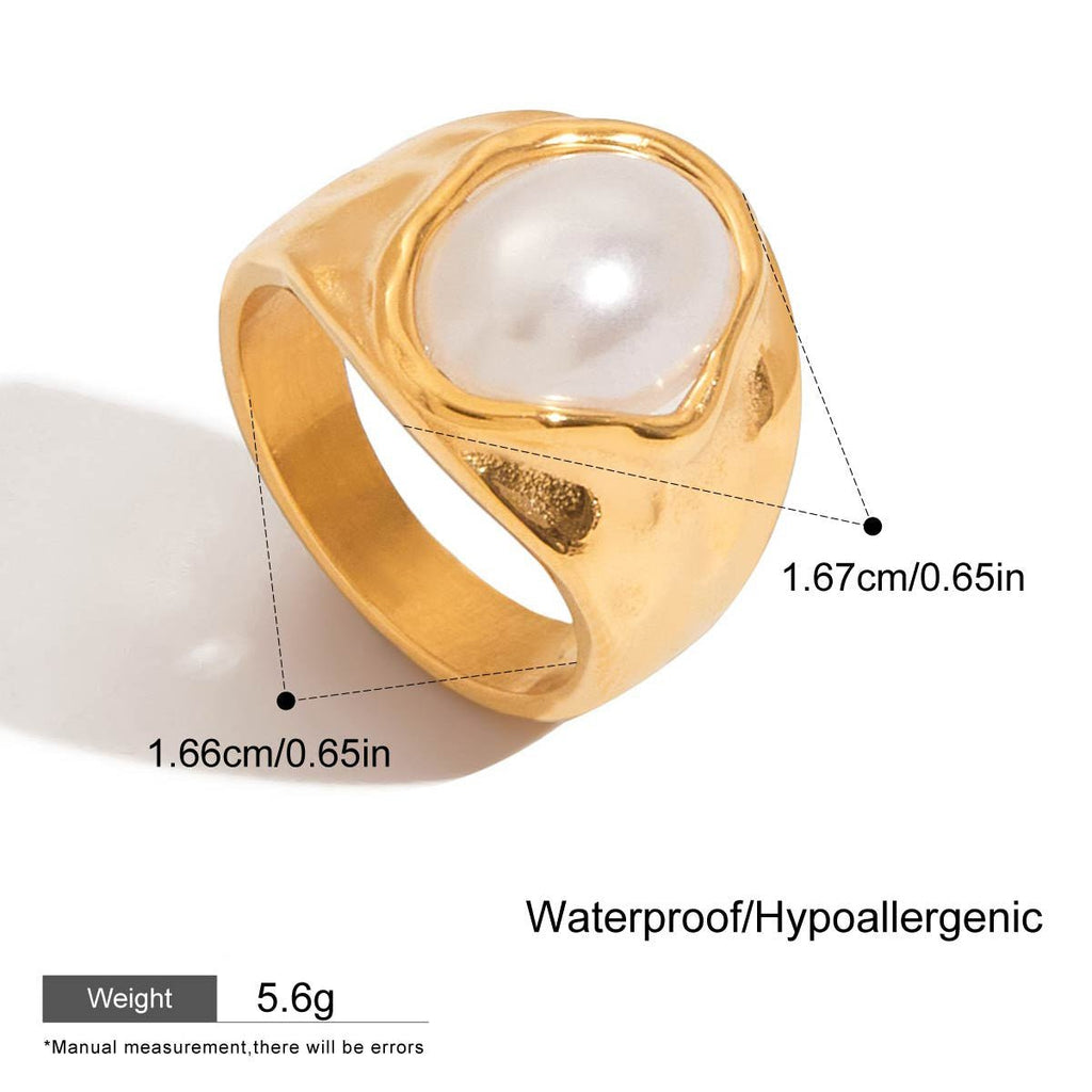 Gold ring with a pearl-like stone on a white background