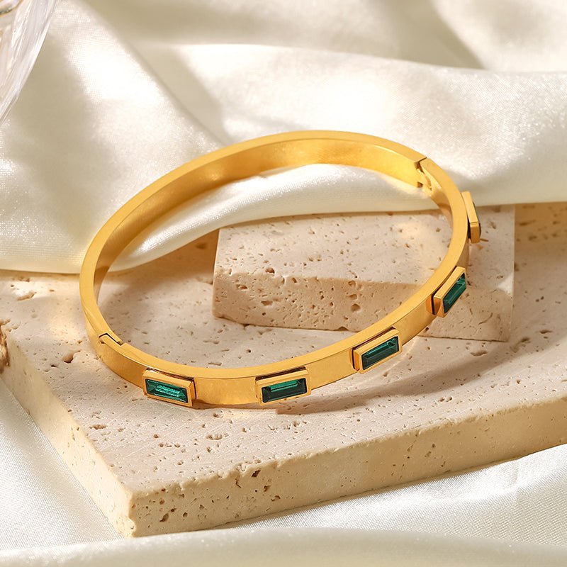 Gold bangle with emerald baguette stones