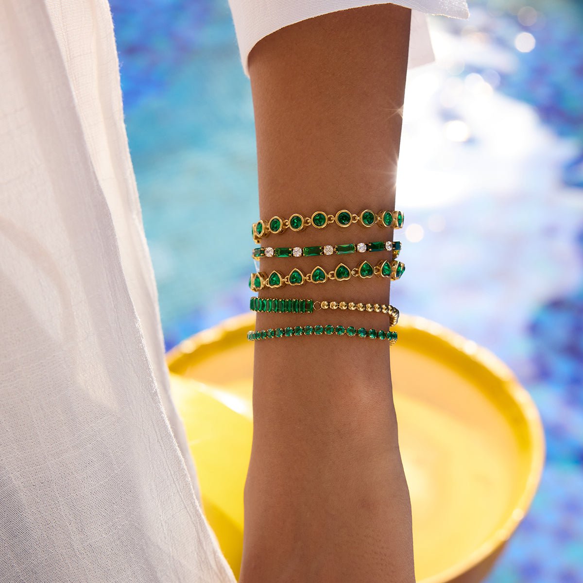 Elegant gold bracelet with emerald green gems