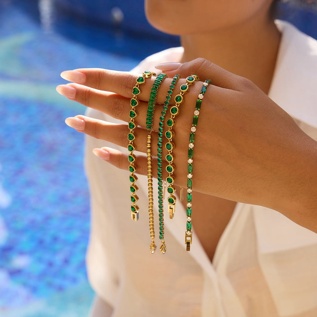 Close-up of gold-plated tennis bracelet with green crystals