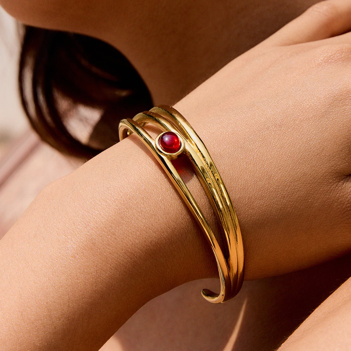 Side view of garnet cuff bracelet in 18k gold finish