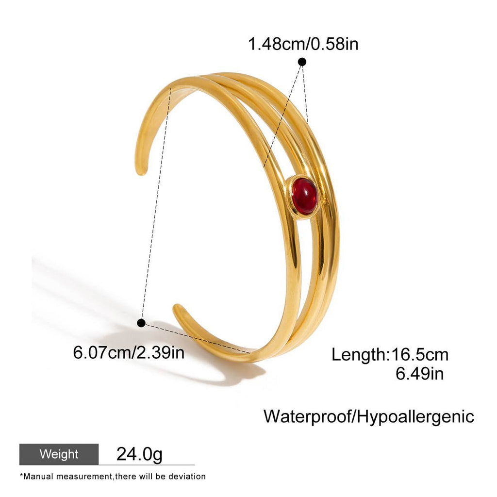 Artistic flat lay of gold garnet cuff bracelet