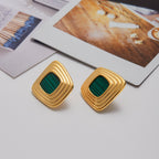 Gold earrings with green centers on a light surface Geometric gold studs with square malachite center

