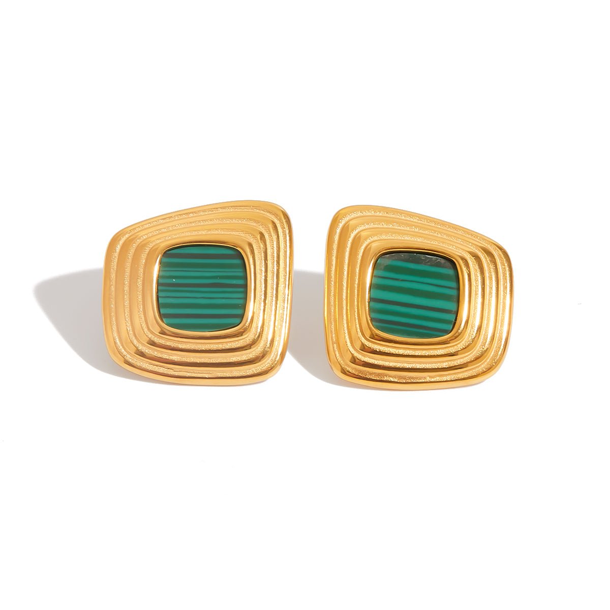 Gold earrings with green stones on a white background