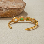 Women's cuff bracelet with bezel-set green gems