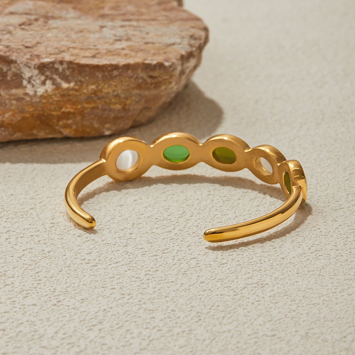Women's cuff bracelet with bezel-set green gems