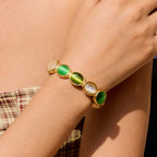 Gold cuff bracelet with green and white oval stones