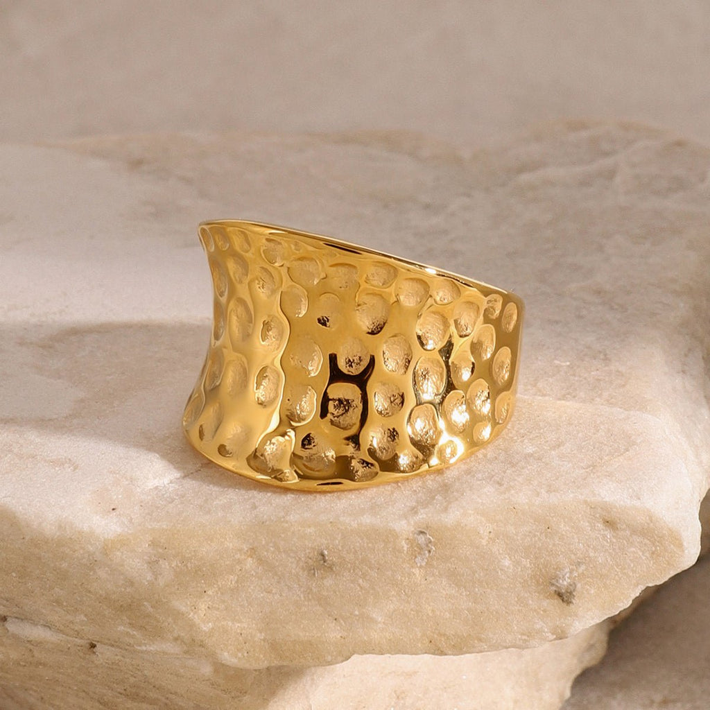 Gold textured ring on a stone surface
