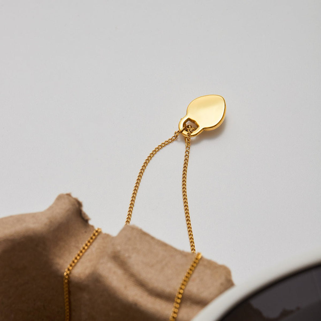 Gold earring on a light gray background