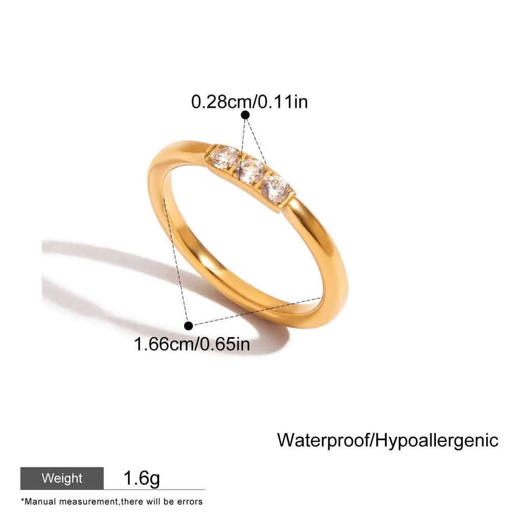 Gold ring with gemstones on a white background, showing measurements and material details.