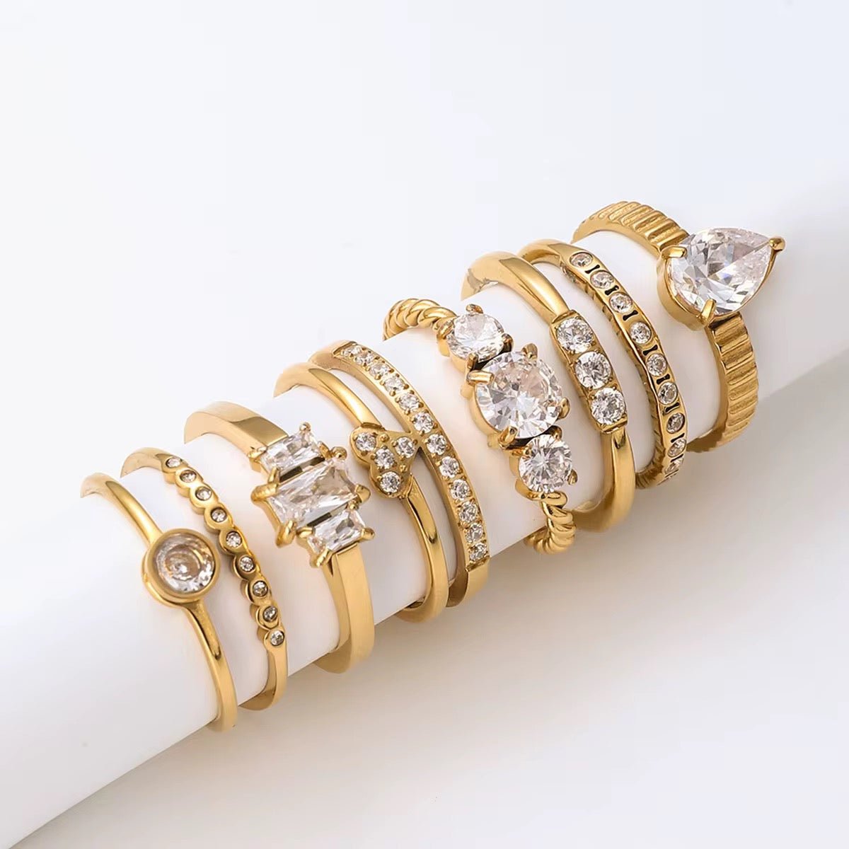 Set of gold and diamond rings on a white surface