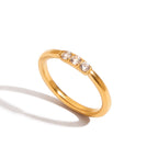 Gold ring with three diamonds on a white background