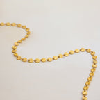 Gold necklace on a light gray background