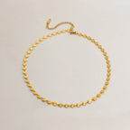 Gold necklace with star-shaped links on a light gray background
