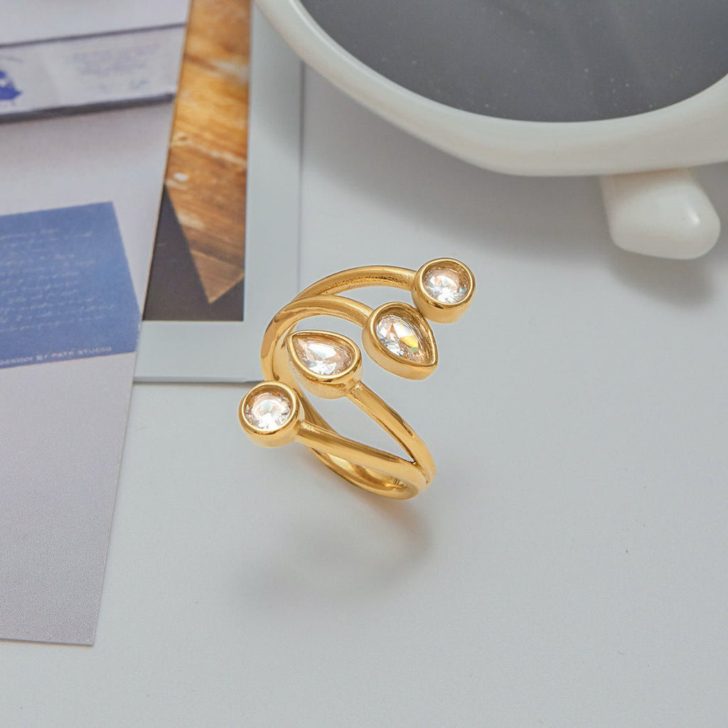 Gold ring with clear stones on a light gray surface