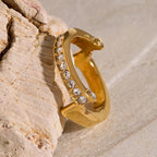 Gold ring with embedded crystals on a stone surface