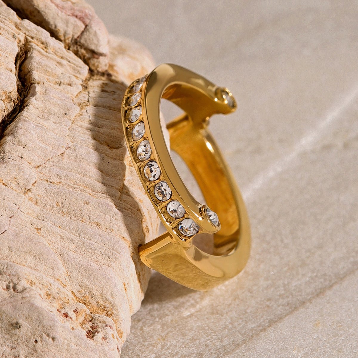 Gold ring with embedded crystals on a stone surface