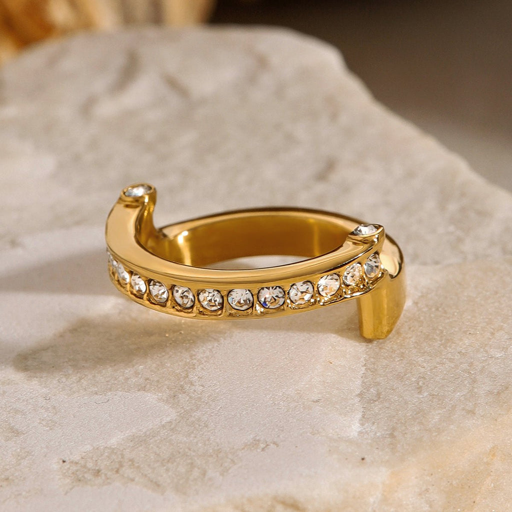 Gold ring with embedded crystals on a textured surface
