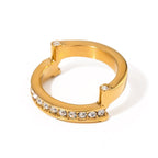 Gold hoop ring with embedded crystals on a white background