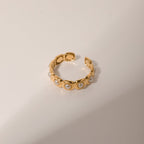 Gold bracelet with pearl-like beads on a beige background