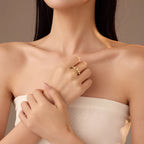 Woman wearing a gold ring on her hand with a neutral background