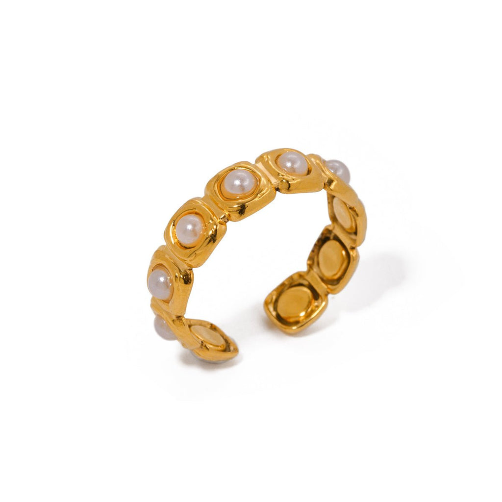 Gold ring with embedded pearls on a white background