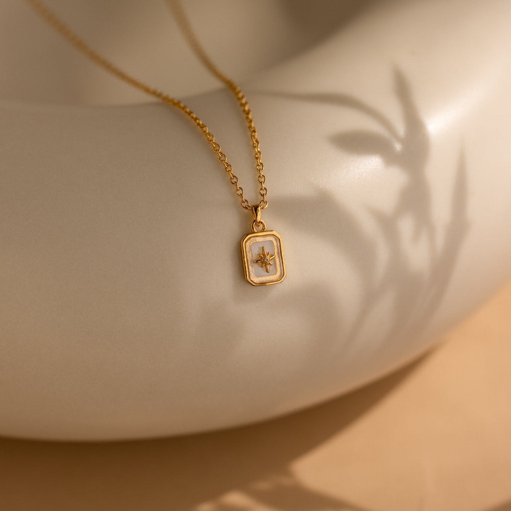 Gold necklace with a pendant on a neutral background
