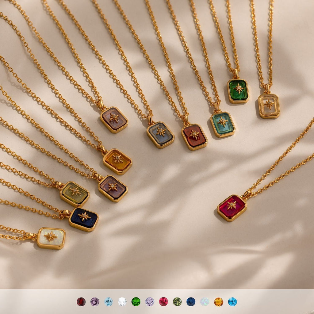 Gold necklaces with colorful pendant stones on a neutral background