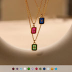 Three gold necklaces with colorful gemstones on a beige background