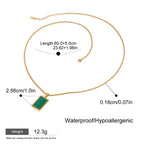 Gold necklace with green pendant and measurement details on a white background