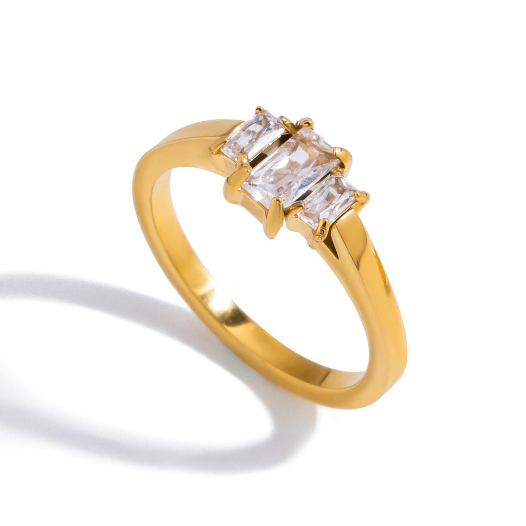 Gold ring with three diamond stones on a white background