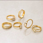 Set of gold rings with various designs on a light background