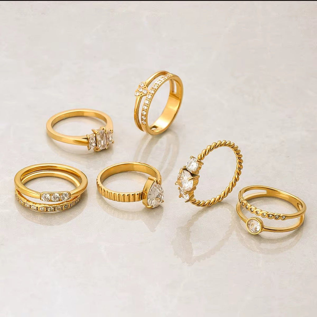 Set of gold rings with various designs on a light background