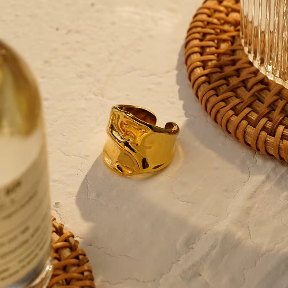 Gold ring on a textured surface with wicker basket in the background