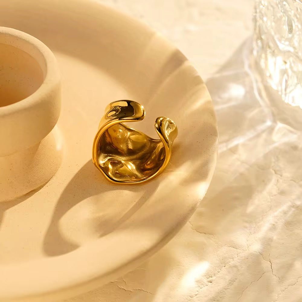 Gold ring on a textured beige surface with soft lighting