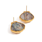 Gold-framed earrings with multicolored stone centers on a white background