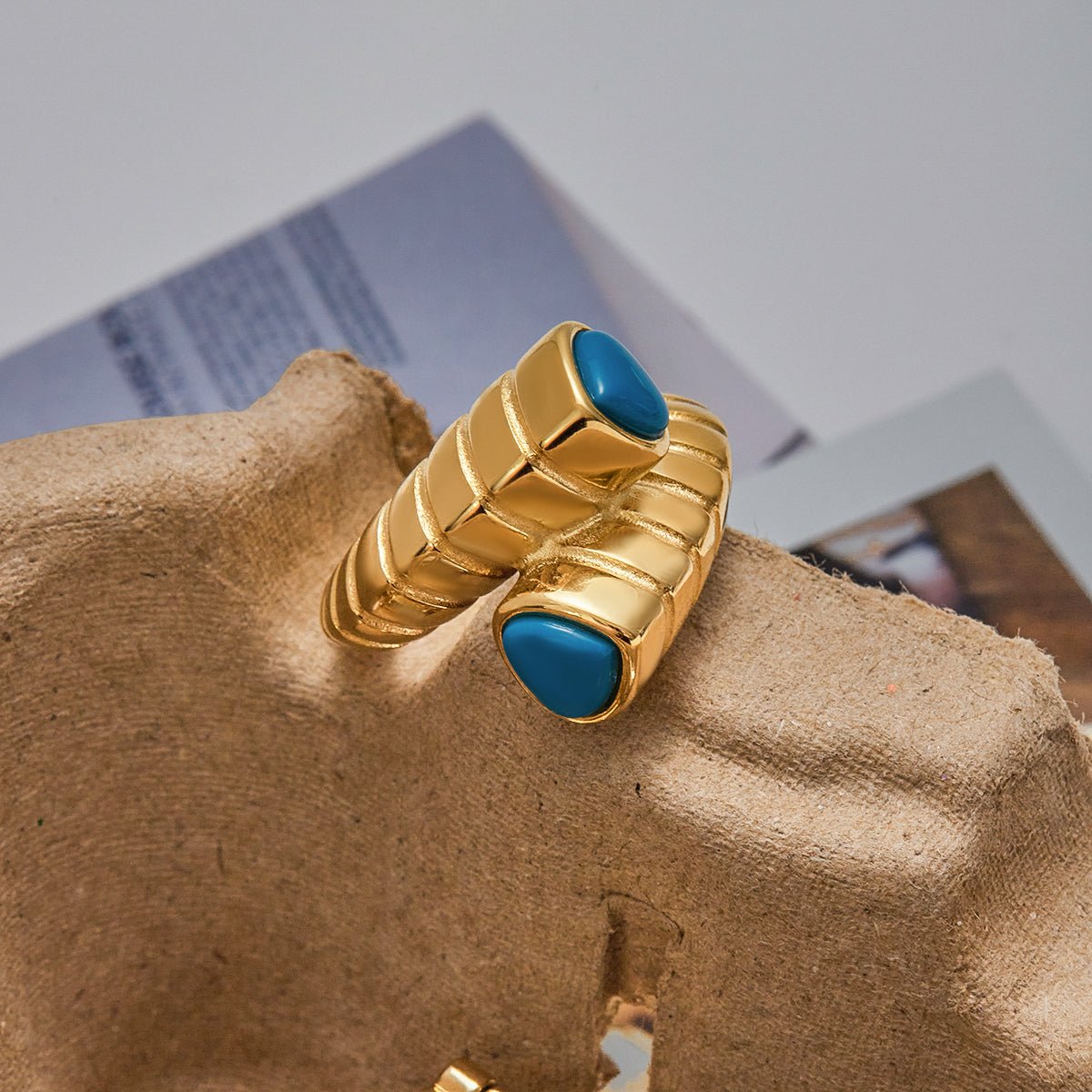 Gold ring with blue stones on a textured surface