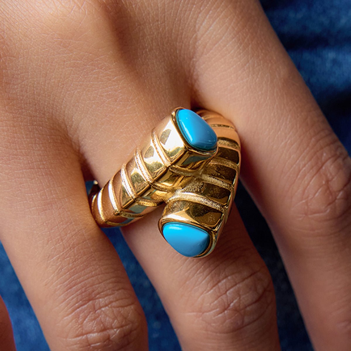 Gold necklace with geometric pendants on a person's neck