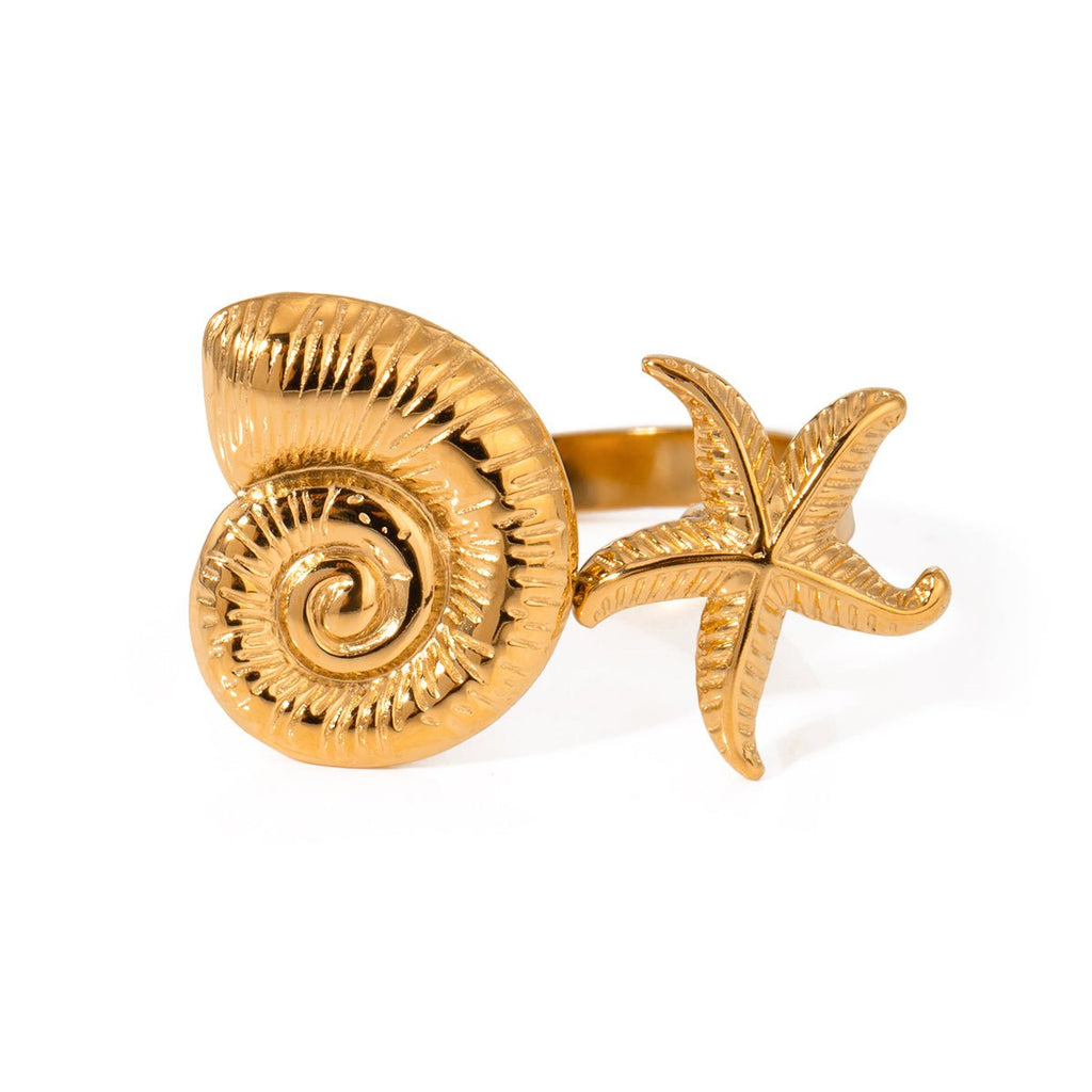 Gold ring with shell and starfish design on a white background