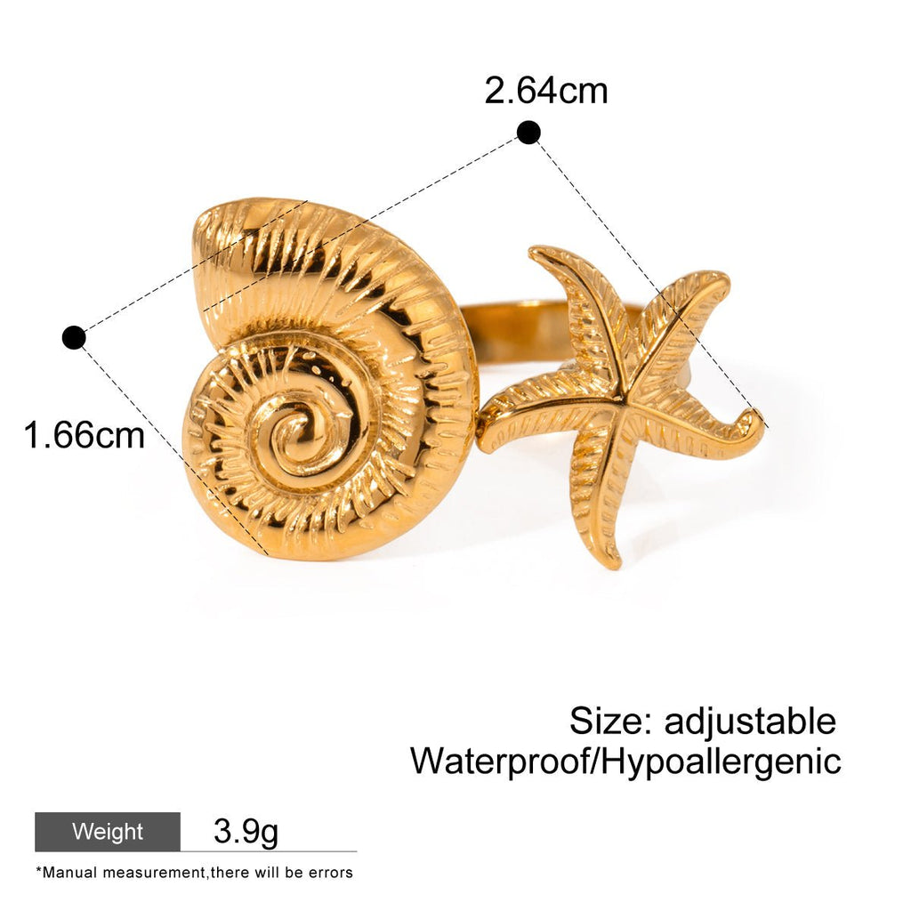 Gold ring with shell and starfish design on a white background